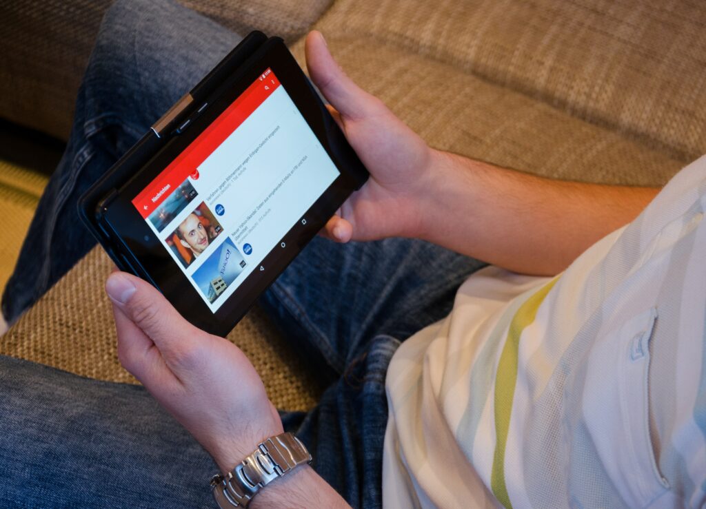 Pexel free to use image for YouTube Shorts. Person holding a tablet watching YouTube videos.